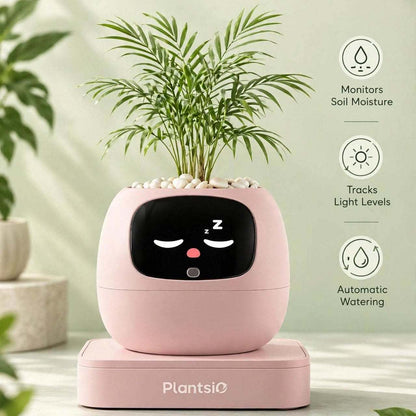Smart Planter in pale pink with a rounded body, black sleepy face display, and leafy green plant on top